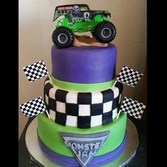 a three tiered cake decorated with green and purple frosting has monster trucks on it