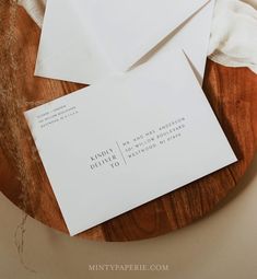 two white envelopes sitting on top of a wooden table