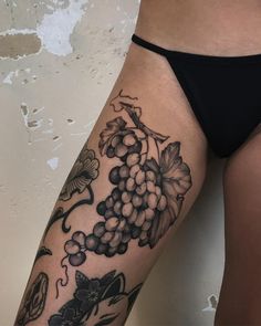 a woman's thigh with grapes and butterflies on it