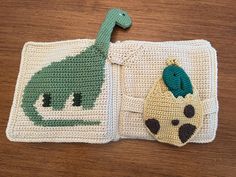 a crocheted book with a green dinosaur on the front and a yellow turtle on the back