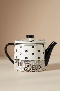 a black and white teapot sitting on top of a table