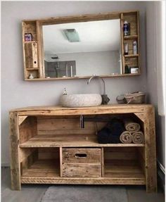 a bathroom with a sink, mirror and wooden cabinet in it's center area