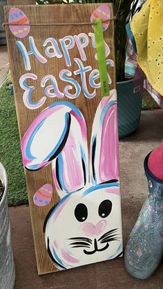 a wooden sign with an easter bunny painted on it