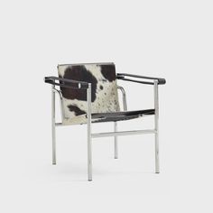 a cow hide chair with chrome frame and armrests