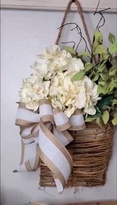 a basket filled with white flowers sitting on top of a wall