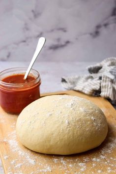 a doughnut sitting on top of a wooden cutting board next to a jar of ketchup