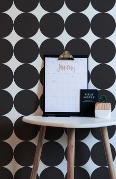 a calendar sitting on top of a white table next to a black and white wall