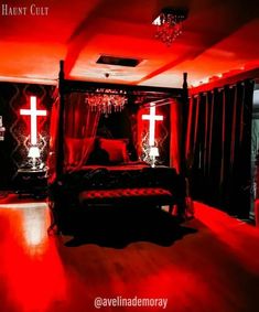 a bedroom decorated in red and black with a cross on the wall