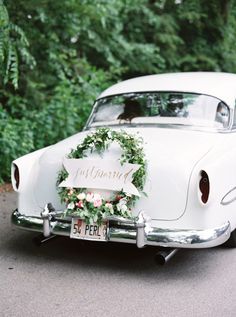 an old white car with a wreath on the front