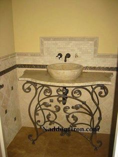 a bathroom sink sitting under a mirror next to a tiled wall