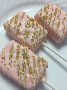 pink and gold cake pops with sprinkles on a white plate