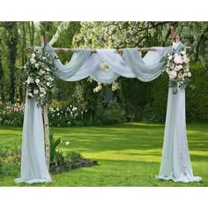 an outdoor wedding ceremony setup with white flowers and draping on the arbors