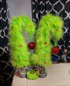 two green christmas decorations on top of a wooden table