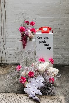 a bouquet of flowers sitting next to a sign that says go on pick me up