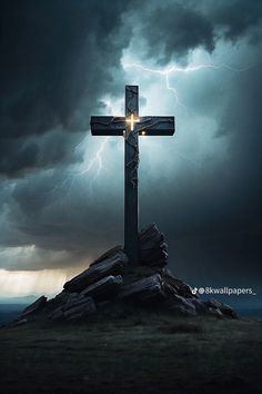 a large cross sitting on top of a rock under a cloudy sky with lightning in the background