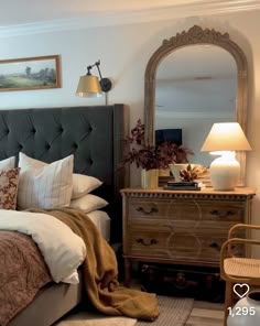 a bedroom with a bed, dresser and mirror in it's centerpieces