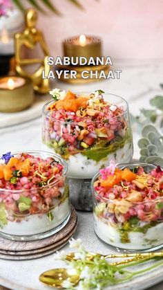 three small bowls filled with food sitting on top of a white plate next to gold spoons