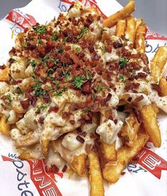 a pile of french fries covered in cheese and bacon