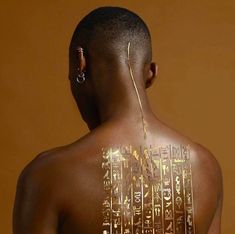 the back of a man's body with gold writing on it