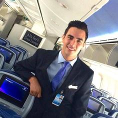 a man in a suit and tie standing on an airplane