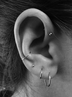 a close up of a person's ear with two piercings