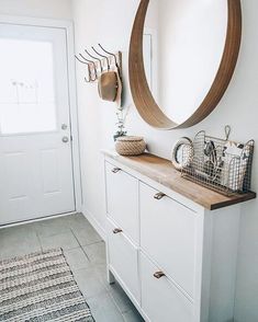 there is a mirror and some baskets on the dresser in this room with white walls