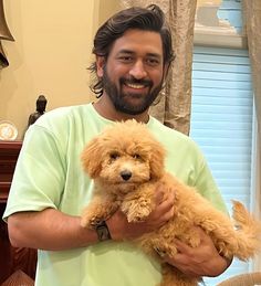 a man holding a brown dog in his arms