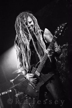 a man with dread hair playing an electric guitar