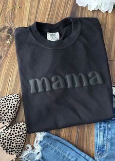 mama Tshirt 3D Puff Print Comfort Colors: Black Hey Mama! Show off your supermom status in our fabulous 3D Puff Print Mama T-Shirt! This cute and trendy tee features a bold "MAMA" design in eye-catching 3D puff print, giving it that extra pop of fun and flair. Product Details: Material: Cozy up in high-quality Comfort Colors fabric that's soft, durable, and oh-so-comfy. Color: Sleek black, perfect for mixing and matching with your favorite outfits. Design: Adorable "MAMA" text in raised 3D puff Vinyl Tee Shirt Ideas, Mama Shirt Ideas Vinyl, Black Crew Neck Tops For Mother's Day, Relaxed Fit Black Top For Mother's Day, Puff Vinyl Sweatshirt Ideas, Puff Print Design, Puff Vinyl Shirt Ideas, Puff Print Tshirt, Vinyl Sweatshirt Ideas