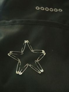 a star shaped pin sitting on top of a black jacket with metal clips attached to it