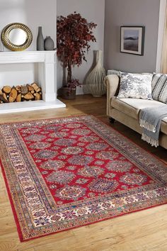 a living room with a red rug on the floor next to a couch and fire place