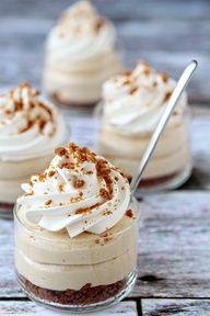 three desserts with whipped cream and cinnamon sprinkles in small glass dishes