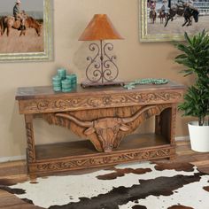 a wooden table sitting on top of a hard wood floor next to a cow skin rug