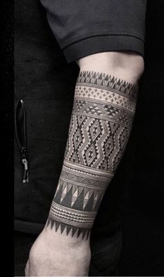 a man with a tattoo on his arm is holding onto a black and white photo