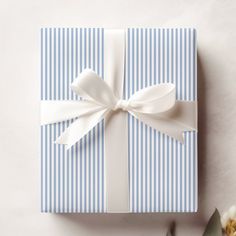 a blue and white striped gift box with a bow