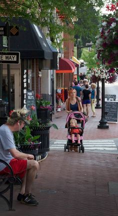 a man sitting on a bench next to a woman with a baby in a stroller