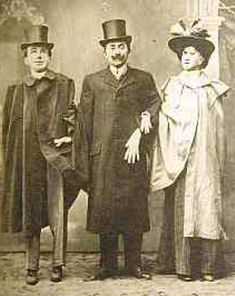 an old black and white photo of three people in fancy clothing, one wearing a top hat