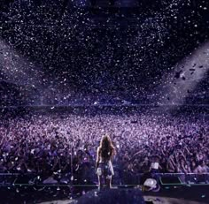 a woman standing on top of a stage surrounded by confetti