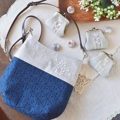 several small purses are sitting on a table next to a potted plant and lace doily