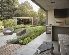 an outdoor kitchen and dining area in a modern home