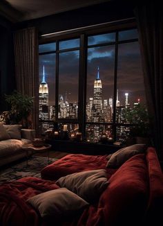 a living room filled with lots of furniture and tall buildings in the background at night