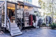 a food truck parked in front of a building with clothes hanging on the outside wall