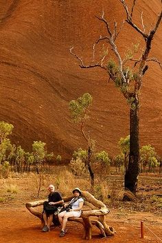 two people sitting on a bench in the desert