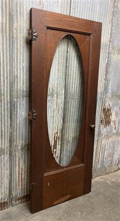 an old wooden door with a mirror on the front and side panel in the middle