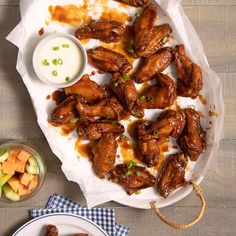 chicken wings with ranch dressing and carrots on a plate next to a bowl of ranch dressing