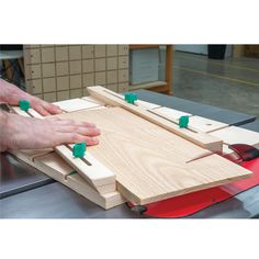 a person is working on a project with wood and green pegs attached to the board