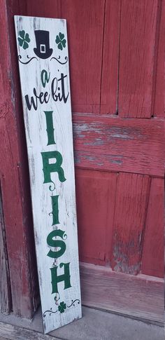 a wooden sign that says it's a wee bit irish next to a red door