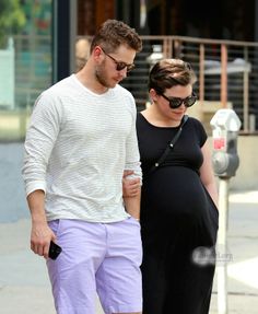 a pregnant couple walking down the street