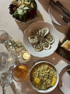 a table topped with plates of food and wine glasses