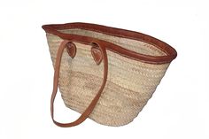 Braided goods from Africa. The bag is handmade from palm fiber, the handles are made from genuine leather. Each part is therefore unique and differs in small features. This basket has two long straps so that it can be carried over the shoulder like a bag.  Dimensions (W x H x D): approx. 54/29 cm x 33 cm x 13 cm, handle length approx. 80 cm  Each product is a unique piece made by hand, that's why isolated deviations and small irregularities are possible and should not be viewed as defects.------ Brown Straw Bag With Adjustable Strap For Market, Natural Leather Beach Bag For Shopping, Natural Leather Handwoven Beach Bag, Handwoven Leather Beach Bag In Natural Color, Natural Beach Bag With Adjustable Strap For Shopping, Rectangular Leather Beach Bag, Bohemian Leather Straw Bag For Beach, Natural Leather Straw Bag For Market, Leather Straw Beach Bag In Bohemian Style